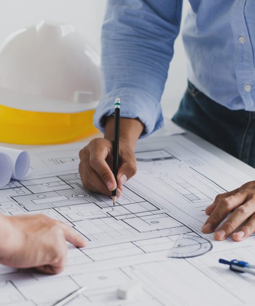 engineer meeting for an architectural project. working with partner and engineering tools working on blueprint architectural project at the construction site at desk in the office.